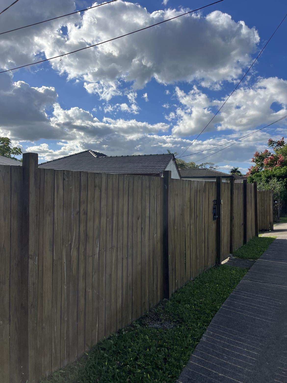 Clear blue sky above the timber fence after the backyard tree was removed